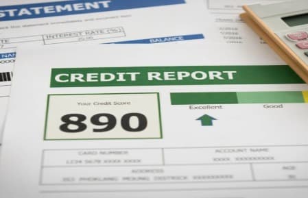 person reviewing credit report, computer screen showing data analysis, financial documents on desk person reviewing credit report, computer screen showing data analysis, financial documents on desk